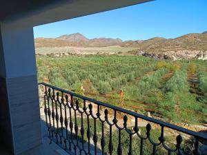 einen Balkon mit Blick auf ein Feld und die Berge in der Unterkunft CASA RURAL CORTIJO MOLINO EL TARAHAL in El Tarahal