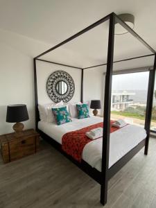 una camera con letto a baldacchino e specchio di Cairnvillas Villa Essencia C45 - Luxury Villa with Private Pool near Beach ad Aljezur
