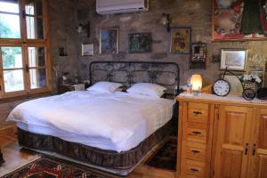 a bedroom with a large bed and a table with a clock at Stone House with Garden in Cunda/Ayvalik in Ayvalık