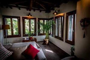sala de estar con sofá y ventanas en Villa Melissa Tsagarada, en Tsagkarada