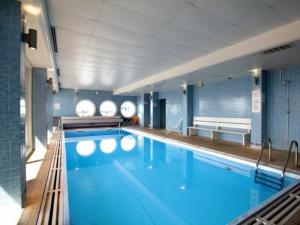une grande piscine avec de l'eau bleue dans un immeuble dans l'établissement Tignes appart 4 pers /piscine/sauna/pied des pistes, à Tignes