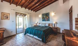 Schlafzimmer mit einem Bett, einem Tisch und einem Fenster in der Unterkunft Cyprus Villages - Bed & Breakfast - With Access To Pool And Stunning View in Tochni