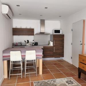 a kitchen with a table and two chairs in it at Sunrise T2 avec jacuzzi vue mer avec accès jacuzzi et piscine in Porto-Vecchio +20 photos