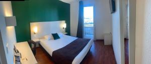 トゥールーズにあるホテル デ ゼタズュニの緑の壁、ベッド付きのベッドルーム1室