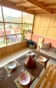 um quarto com uma mesa de madeira com pratos em Moana Surf Maroc em Tamraght Ouzdar