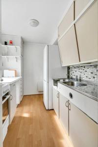 eine Küche mit einem weißen Kühlschrank und Holzböden in der Unterkunft Fully equipped independent apartment near NTNU,Lerkendal og center in Trondheim
