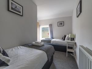 1 dormitorio con 2 camas y ventana en Chestnut House- 2 Bedroom house in Ashington, Northumberland, en Ashington