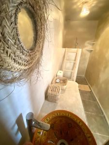 uma casa de banho com um lavatório e um espelho na parede em Moana Surf Maroc em Tamraght Ouzdar