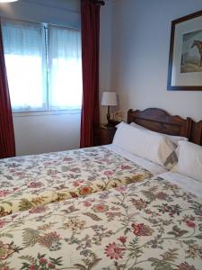 1 dormitorio con 1 cama con colcha de flores en Hotel Los Caspios, en Colunga