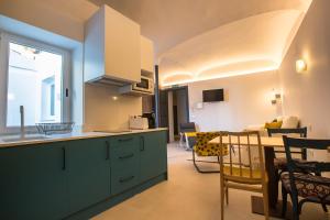 a kitchen with green cabinets and a dining room at Apartamentos San Salvador Parking Gratis in Mérida