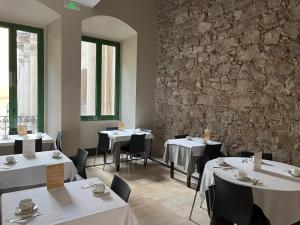 a restaurant with tables and chairs and a stone wall at Hotel Sant Agustí in Barcelona