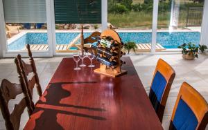 einen Esstisch mit Weingläsern und einen Pool in der Unterkunft House Bosnic in Cista Provo