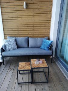 - un canapé bleu assis sur une terrasse couverte avec une table dans l'établissement Aurinkoranta D6, à Kalajoki