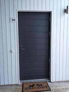 - une porte de garage noire avec un panneau d'affichage dans l'établissement Aurinkoranta D6, à Kalajoki