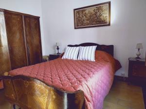 1 dormitorio con 1 cama con edredón rosa en Alquiler temporario Don Floreal en San Antonio de Areco