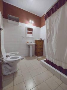 y baño con aseo y lavamanos. en Alquiler temporario Don Floreal en San Antonio de Areco