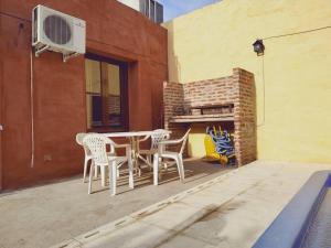 un patio con mesa y sillas junto a un edificio en Alquiler temporario Don Floreal en San Antonio de Areco