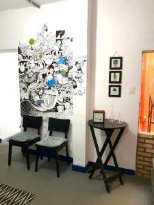 a room with two chairs and a table and a wall at Vilarejo Hostel Pinheiros Guest House in Sao Paulo