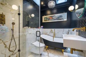 a bathroom with a tub and a sink and a bath tub at Unique Chic Two Bed House Richmond in Richmond upon Thames +13 photos