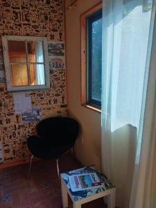 a room with a chair and a window and a table at Hermoso Loft, con estacionamiento gratuito in Talca
