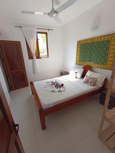 1 dormitorio con 1 cama con sábanas blancas y ventana en Jua Apartments, en Kiwengwa