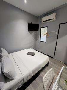 1 dormitorio blanco con 1 cama y 1 silla en Gurney Coast Guest House by Sky Hive, en George Town