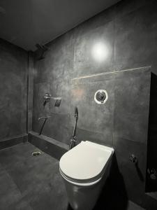 a bathroom with a white toilet in a room at Achala Home in Guwahati