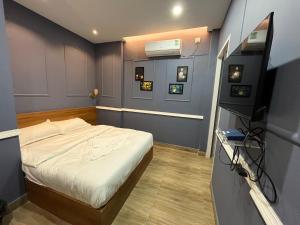 a small bedroom with a bed and a television at Achala Home in Guwahati