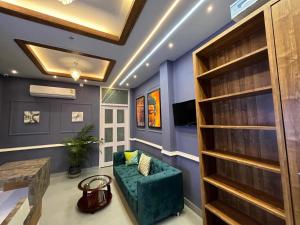 a living room with blue walls and a green couch at Achala Home in Guwahati