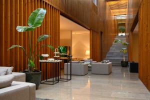 a lobby with couches and plants and a staircase at Inspira Liberdade Boutique Hotel in Lisbon