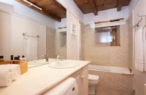 a white bathroom with a sink and a toilet at Tarter Chalets Apartaments in El Tarter +47 photos