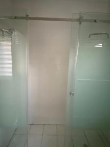 a bathroom with a shower and a glass door at Our Nice Home in Kaduna