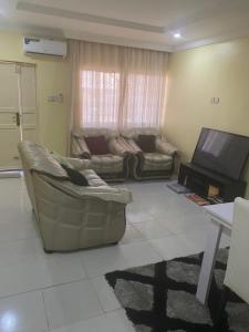 a living room with a couch and a tv at Our Nice Home in Kaduna
