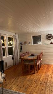 uma sala de jantar com uma mesa de madeira e cadeiras em Cozy little house in Tromsø city em Tromsø