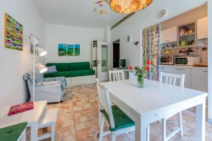 un soggiorno con tavolo bianco e cucina di Casa Luisa Relax & Outdoor in Finale a Finale Ligure