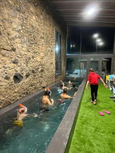un groupe de personnes dans une piscine dans l'établissement Casa Rural el Serrat de Baix, à Sant Joan les Fonts