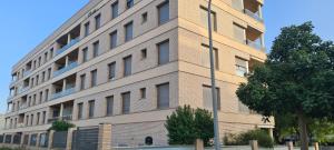Un edificio alto de ladrillo con un árbol delante. en Port Blau Cambrils, en Cambrils