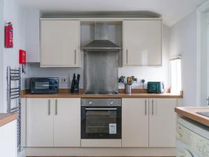 a kitchen with white cabinets and a stove top oven at Haw thorn House - 2 bedroom, Ashington, Northumberland in Ashington