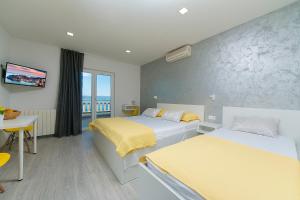 um quarto de hotel com duas camas e uma varanda em Apartments Vila Nadalina Delux em Brela