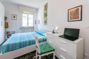 una camera con un letto e un computer portatile su un comò di Casa Luisa Relax & Outdoor in Finale a Finale Ligure