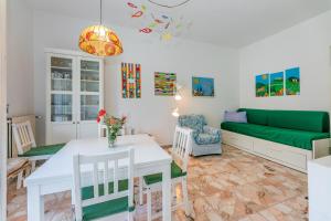 un soggiorno con tavolo bianco e divano verde di Casa Luisa Relax & Outdoor in Finale a Finale Ligure