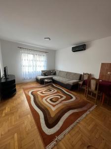un salon avec un canapé et un tapis dans l'établissement Kod Labuda, à Ivanjica