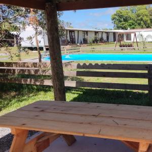 a wooden bench sitting in front of a pool at HABITACIONES ALUC, se reserva solo con seña in Chuy +28 photos