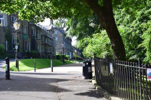 a wrought iron fence next to a street with houses at The Buxton Retreat A Luxurious 3-Storey Townhouse with Four Poster Bed and Double Jacuzzi Bath" in Buxton