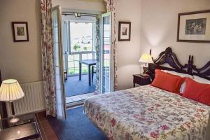 a bedroom with a bed and a door to a balcony at Hotel Los Caspios in Colunga