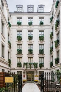 a white building with potted plants on the windows at Maison Colbert Member of Meliá Collection in Paris