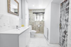 a white bathroom with a sink and a toilet at Cyprus Villages Hotel & Restaurant - Central Location - Bed & Breakfast - With Access To Pool And Stunning Views in Tochni