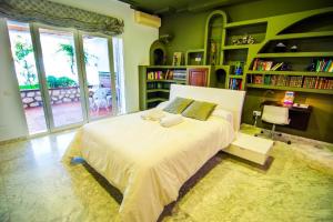 ein Schlafzimmer mit einem großen Bett in einem Zimmer mit Bücherregalen in der Unterkunft 16:9 Los Molinos Suites in Almería