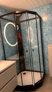 a shower in a room with a blue wall at Cozy little house in Tromsø city in Tromsø