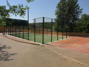 a tennis court with a fence on a tennis court at Camping Hoces de Mira in Mira